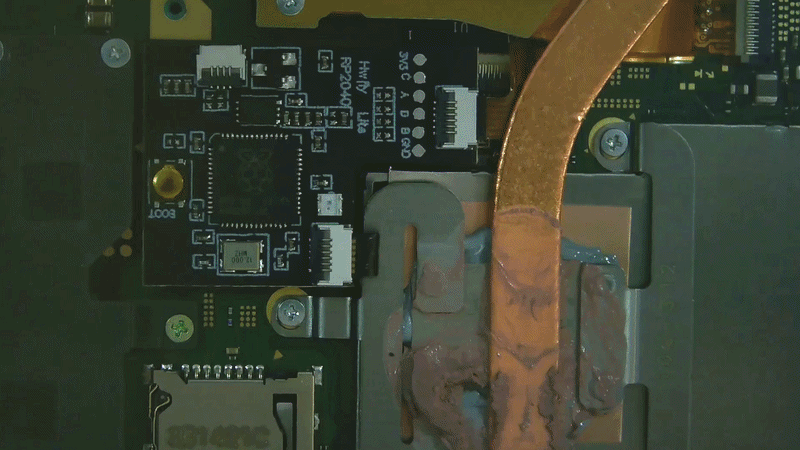 Animated GIF showing the RP2040 modchip during the Nintendo Switch Lite boot process, with the blue LED flashing while attempting the glitch sequence followed by a successful green LED indication after the console boots correctly.